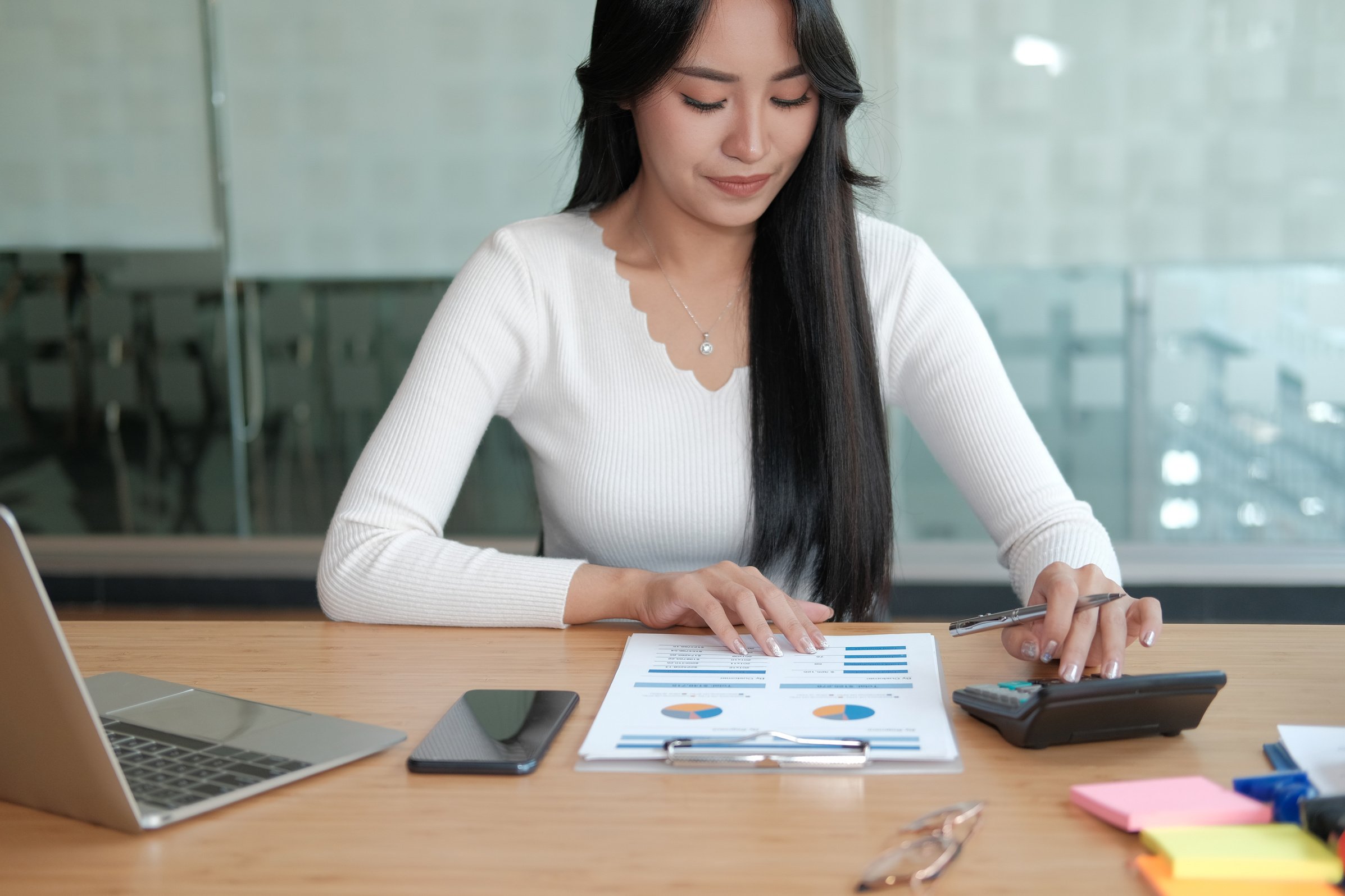 Woman Using Calculator At Work
